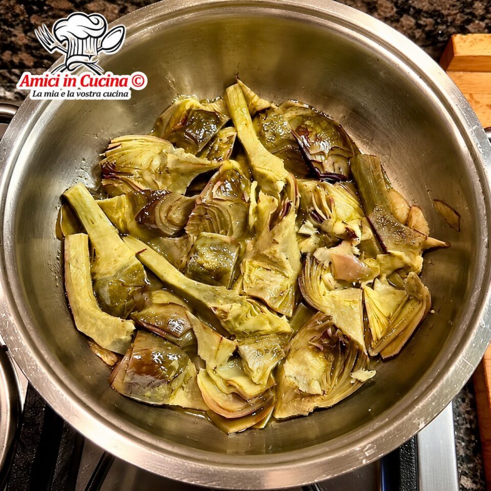 Tegame in acciaio sul fornello pieno di spicchi di carciofi tenerissimi stufati in padella con olio e prezzemolo, preparati da Giuseppe Crociata