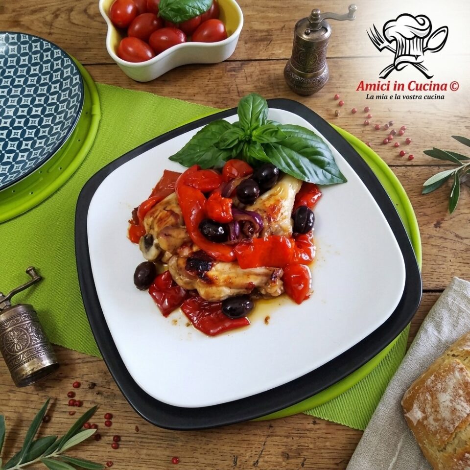 Porzione di pollo alla cacciatora servita in piatto bianco con foglia di basilico, pane casereccio e macinino per il pepe.