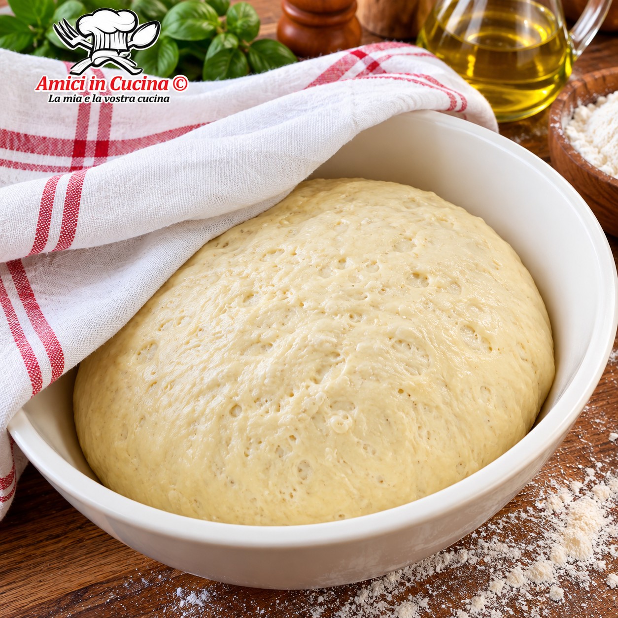 Ciotola bianca contenente una palla di impasto per pizza perfettamente lievitato, liscio e gonfio, parzialmente coperto da un canovaccio di cotone bianco