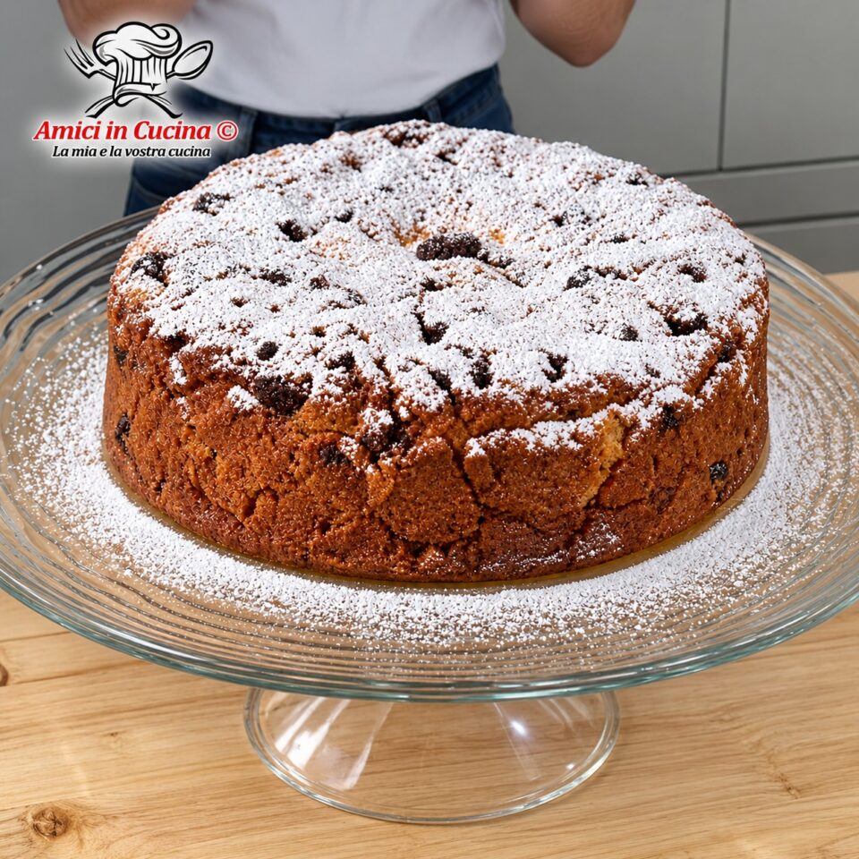 Fetta di torta rustica e morbida a base di pane e latte, spolverata di zucchero a velo, dove si intravedono pezzi di noci e fichi secchi