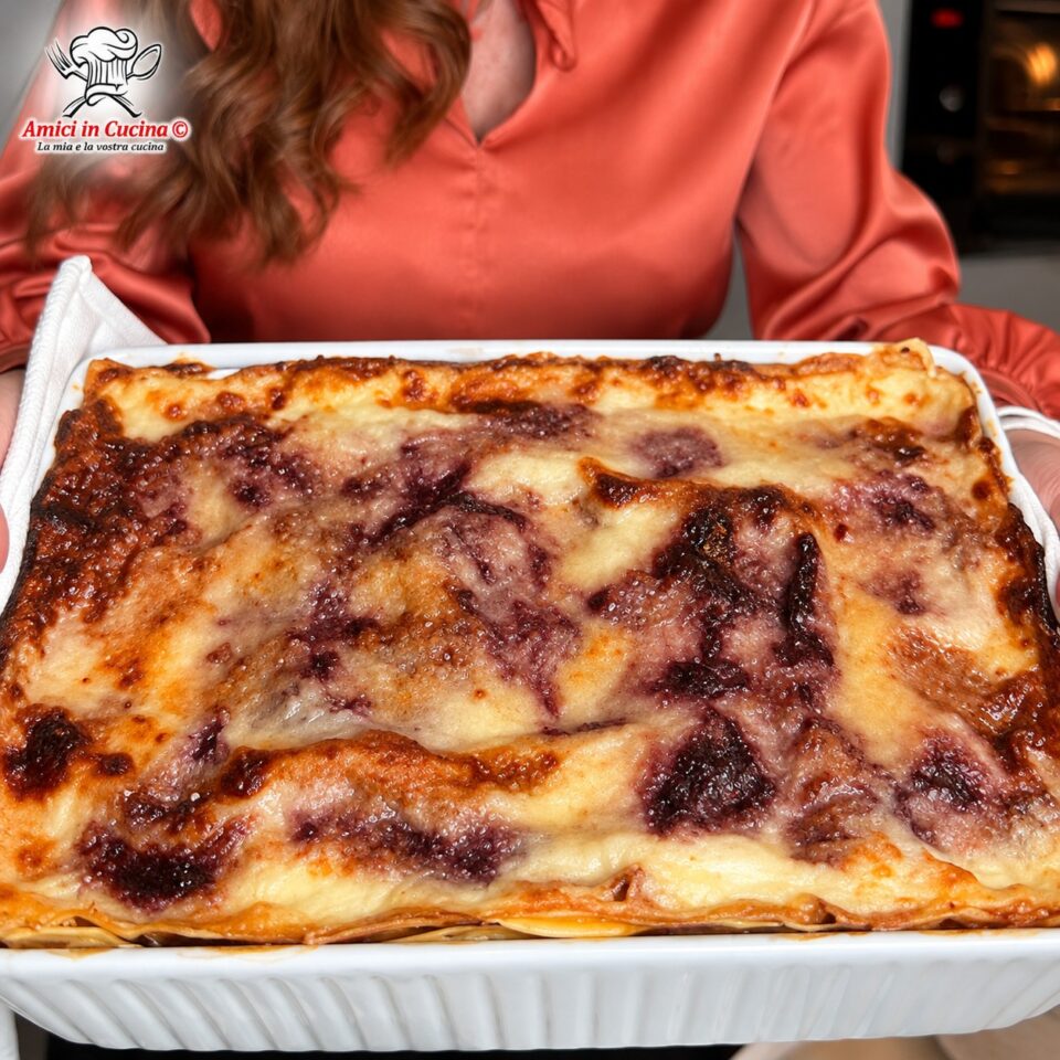 Teglia rettangolare di lasagne appena sfornate, con una ricca crosticina dorata di formaggio grattugiato e sfumature violacee date dal radicchio