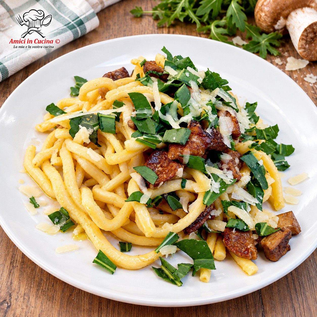 Piatto di pasta fresca formato scialatielli, condita con funghi porcini a pezzetti e guarnita abbondantemente con rucola fresca tritata e formaggio a scaglie