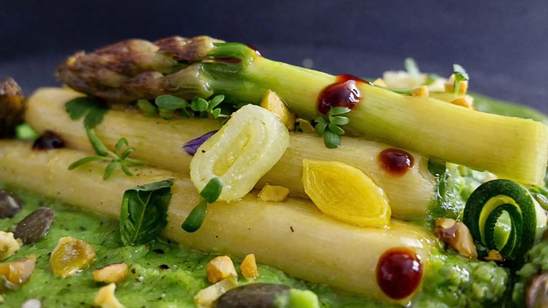 Asparagi al burro su crema di piselli con rondelle di zucchine, porro e granella di pistacchi