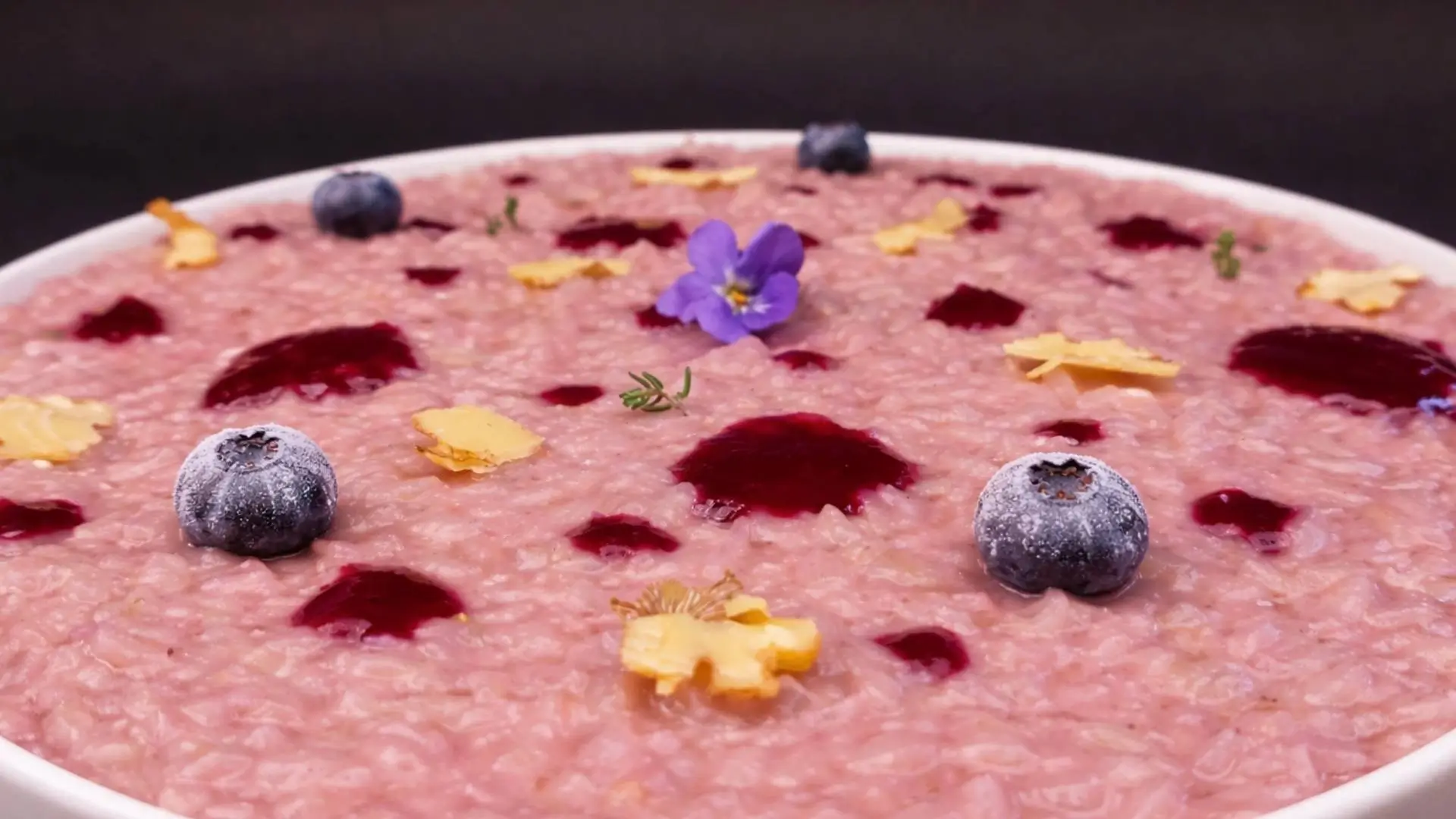 Risotto ai mirtilli con lamelle di noci e una violetta al centro