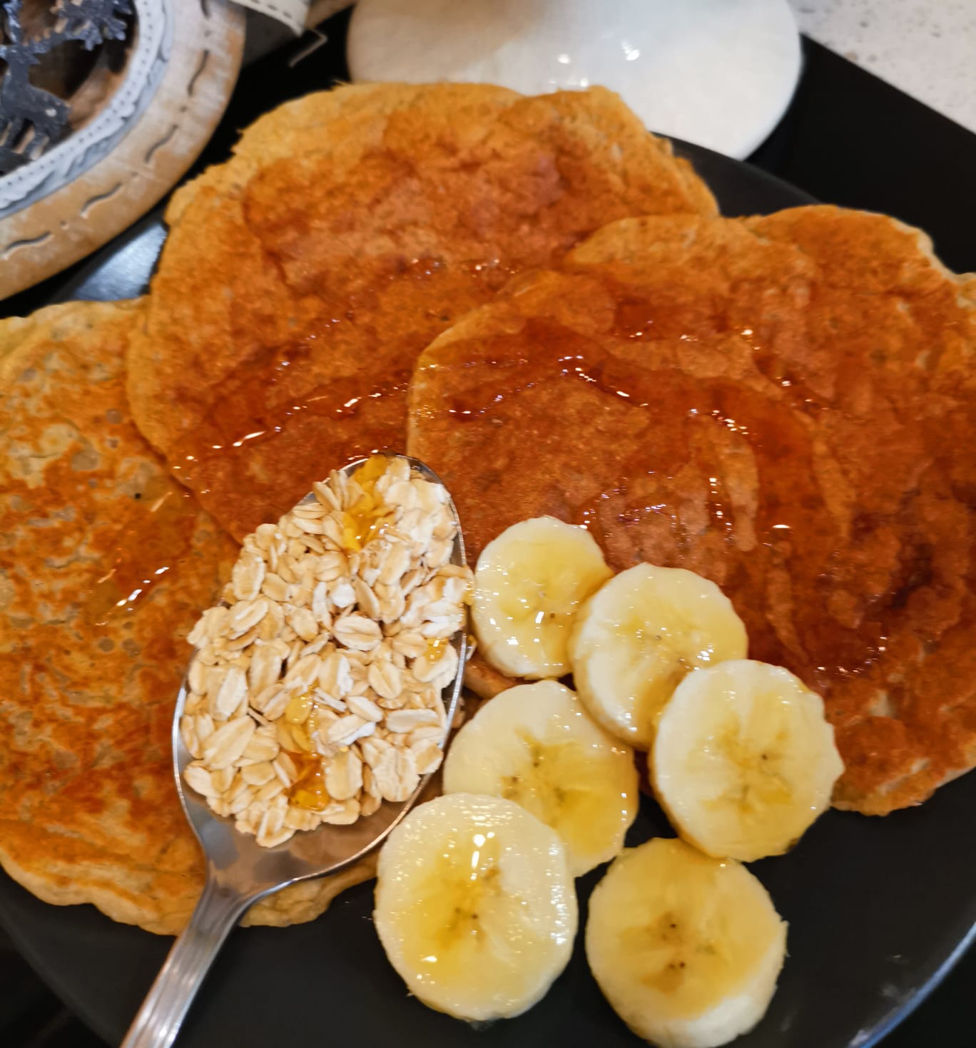 Pancake con farina di avena yogurt greco e banana soffici serviti con banana fresca e fiocchi di avena