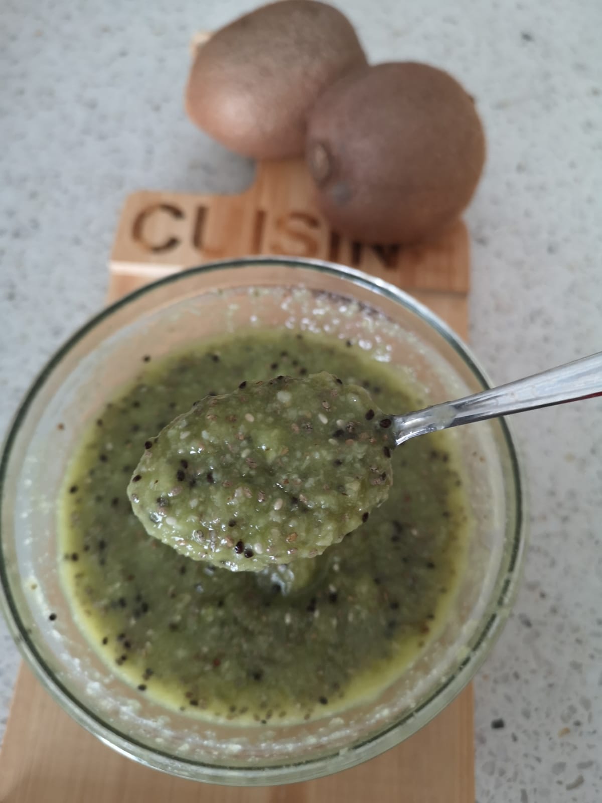 Composta di kiwi e semi di chia in una ciotola di vetro con cucchiaio