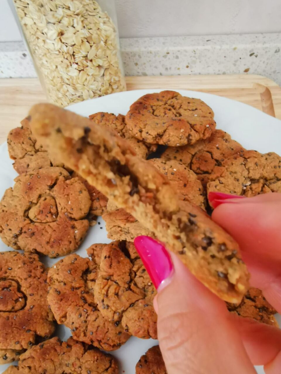 Biscotto all'avena spezzato a metà che mostra la consistenza friabile e l'interno rustico con semi di chia