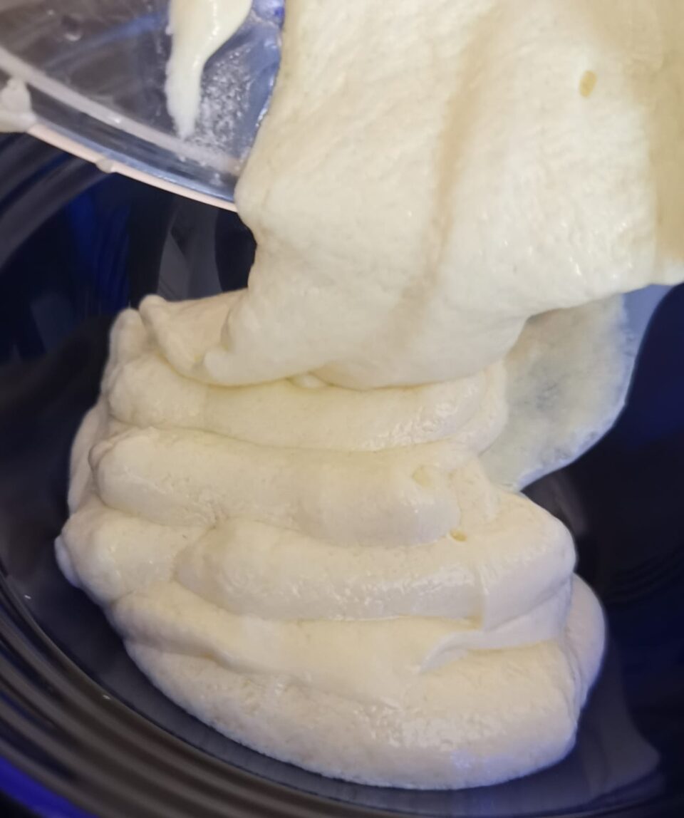 Maionese furba di uova sode e ricotta frullata con il minipimer che cola densa a nastro nella ciotola.