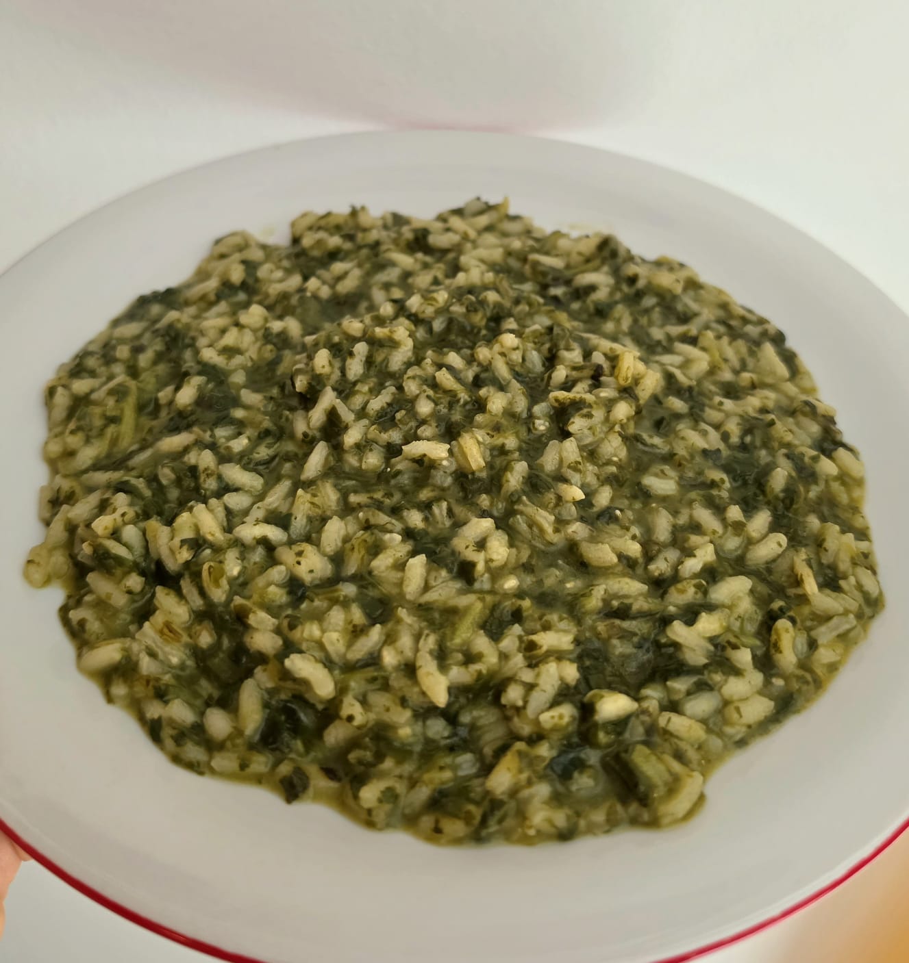 Piatto di risotto cremoso con bietole, spinaci e zafferano pronto da servire.
