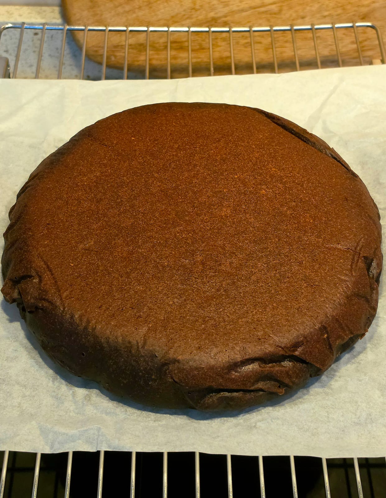Torta al cioccolato al rum senza uova intera e soffice adagiata su carta forno.