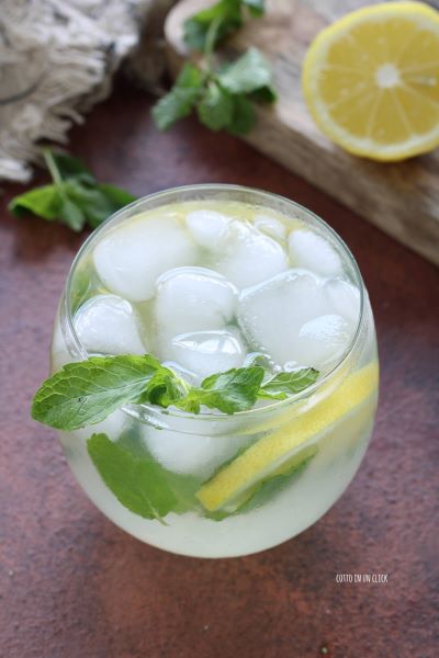 versa nel bicchiere con del ghiaccio e le fette di limone la limonata e servi con foglie di menta