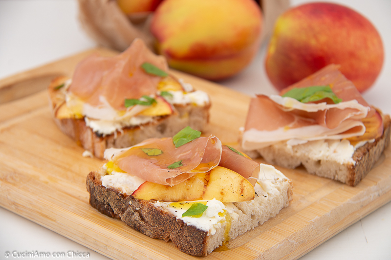 Crostini con caprino pesche e crudo
