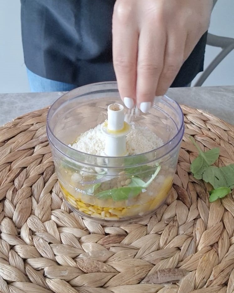 aggiungete al mixer la buccia di limone, pinoli, basilico, aglio, parmigiano, succo di limone.