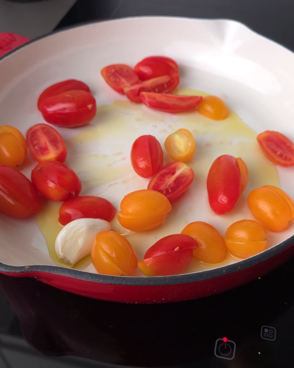 in padella aglio olio e pomodorini divisi a metà