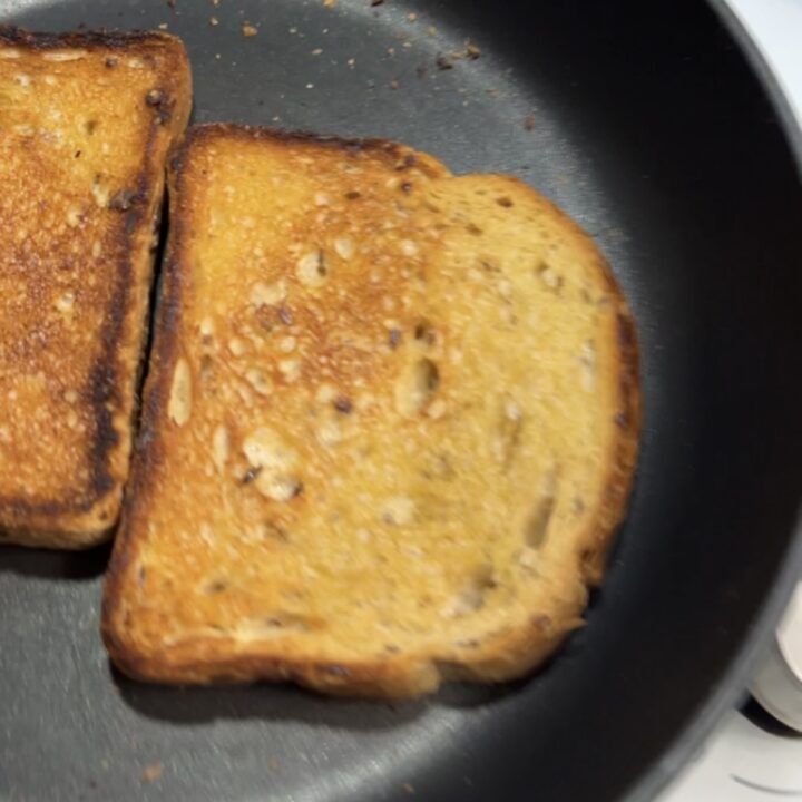 Tosta le fette di pane in padella rigirandole da entrambi i lati fino a dorarle per bene.