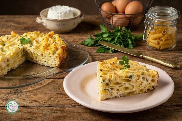 Frittata di pasta con ricotta al forno morbida e dorata, preparata con pasta corta, ricotta, parmigiano e uova, servita a fette