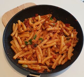 aggiunta della mollica tostata alla pasta con peperoni arrostiti e nduja