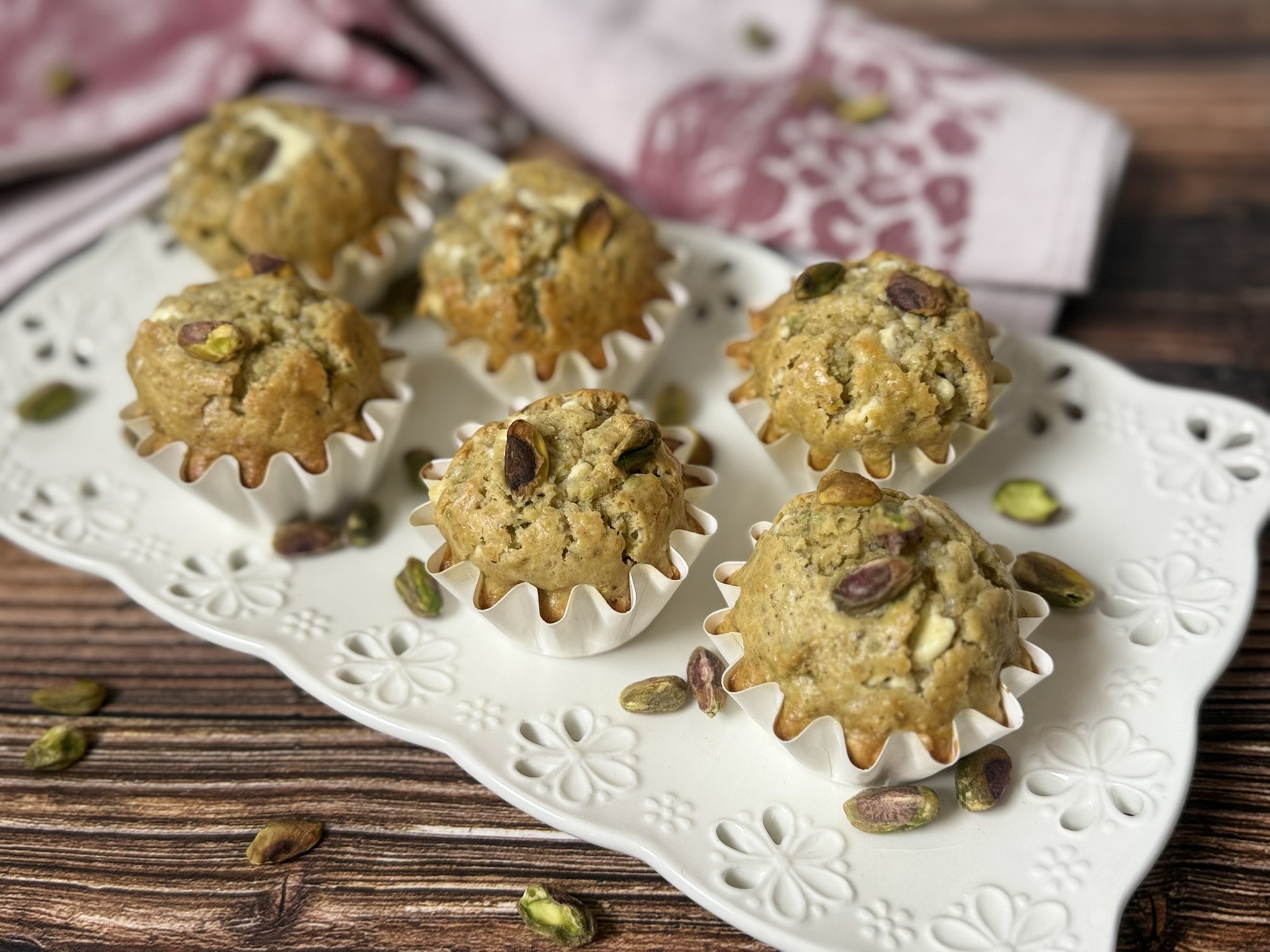 MUFFIN PISTACCHIO E CIOCCOLATO BIANCO, RICETTA FACILE PER MUFFIN SOFFICI E PROFUMATI SERVITI SU UN VASSOIO DI PORCELLANA BIANCA