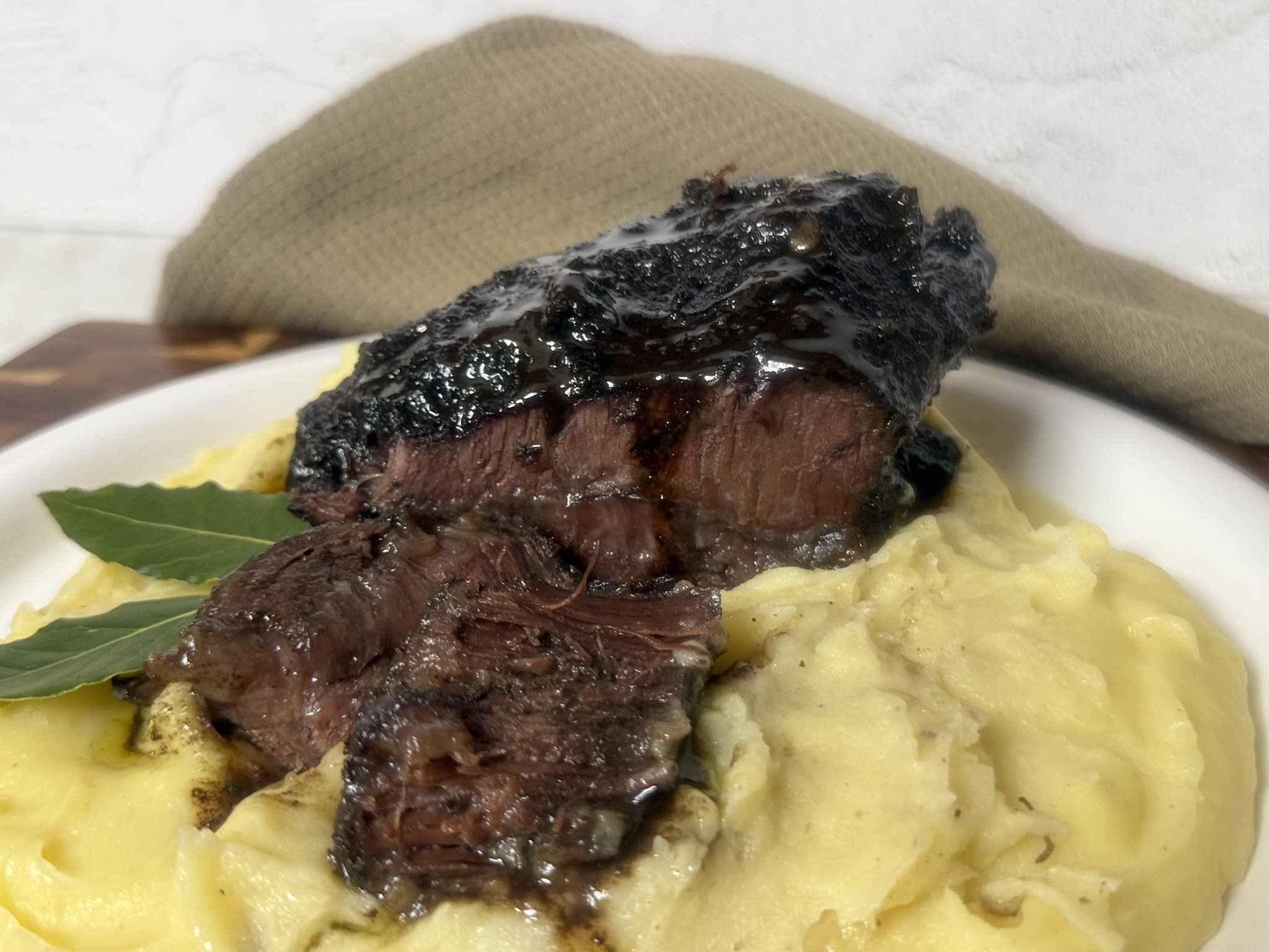 Guancia di manzo brasata al vino rosso servita su purè di patate cremoso, carne tenerissima e succosa