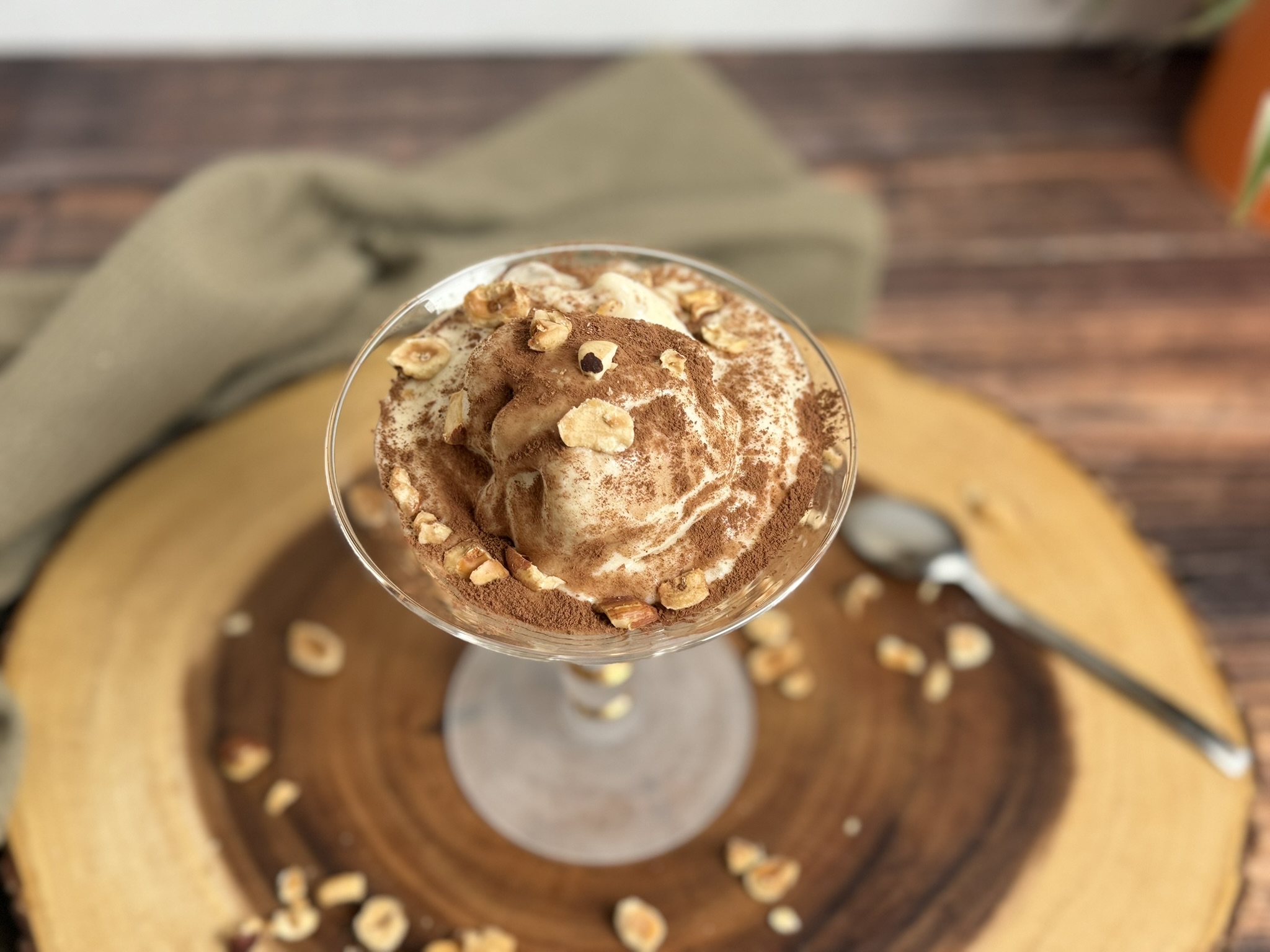 gelato alla banana senza lattosio, facile e veloce senza gelatiera, servito in una coppa di vetro con spolverata di cacao amaro e granella di nocciole.