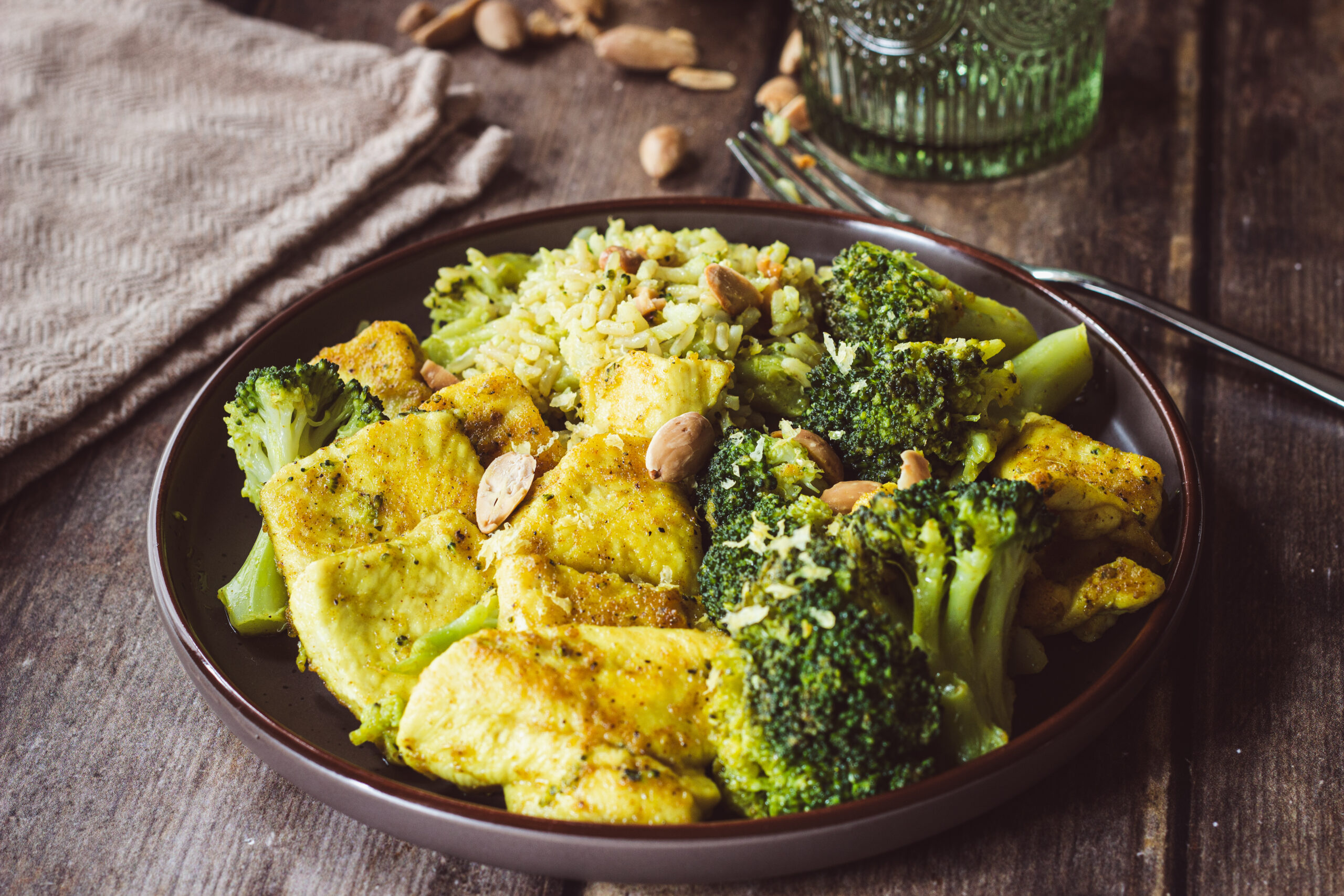 pollo al curry in padella con broccoli, riso e mandorle tostate