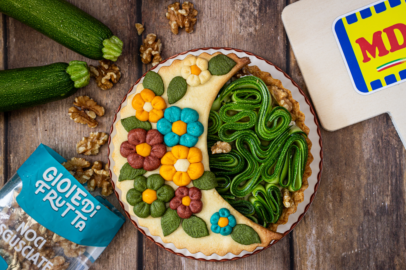 Crostata salata di zucchine e noci, con decoro floreale