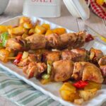 Spiedini di carne mista in padella con patate e peperoni