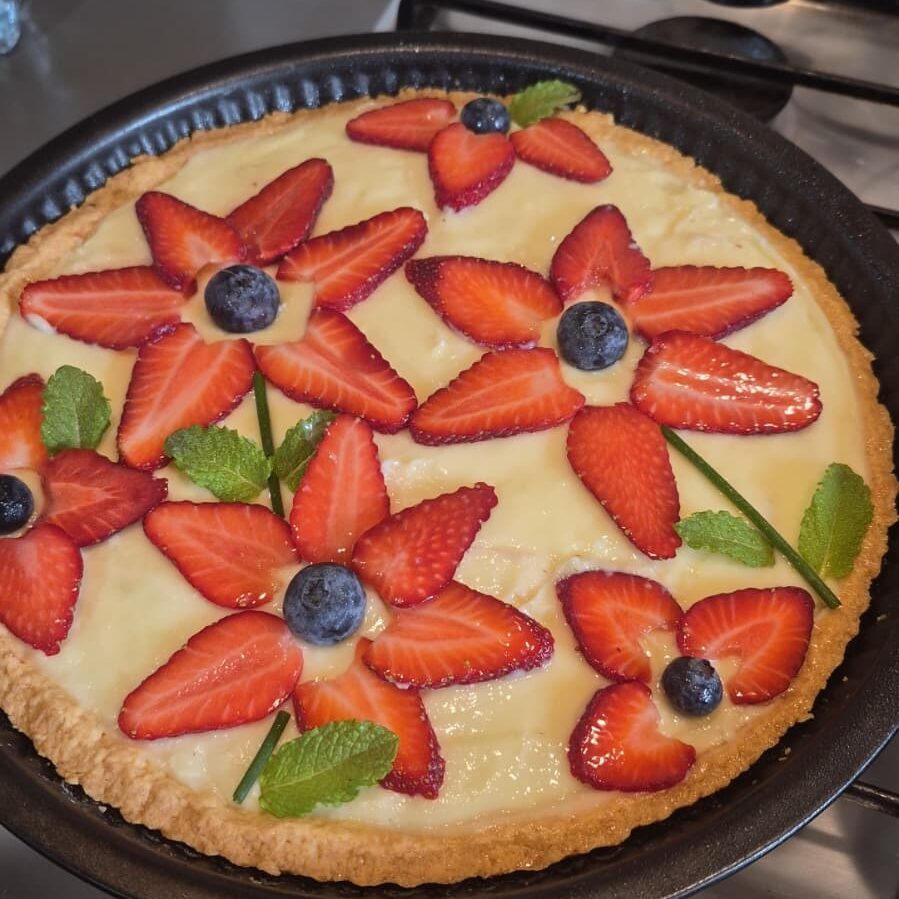 Crostata Primavera con crema e decorazioni di frutta a forma di fiori