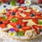 Crostata Primavera con crema e decorazioni di frutta a forma di fiori