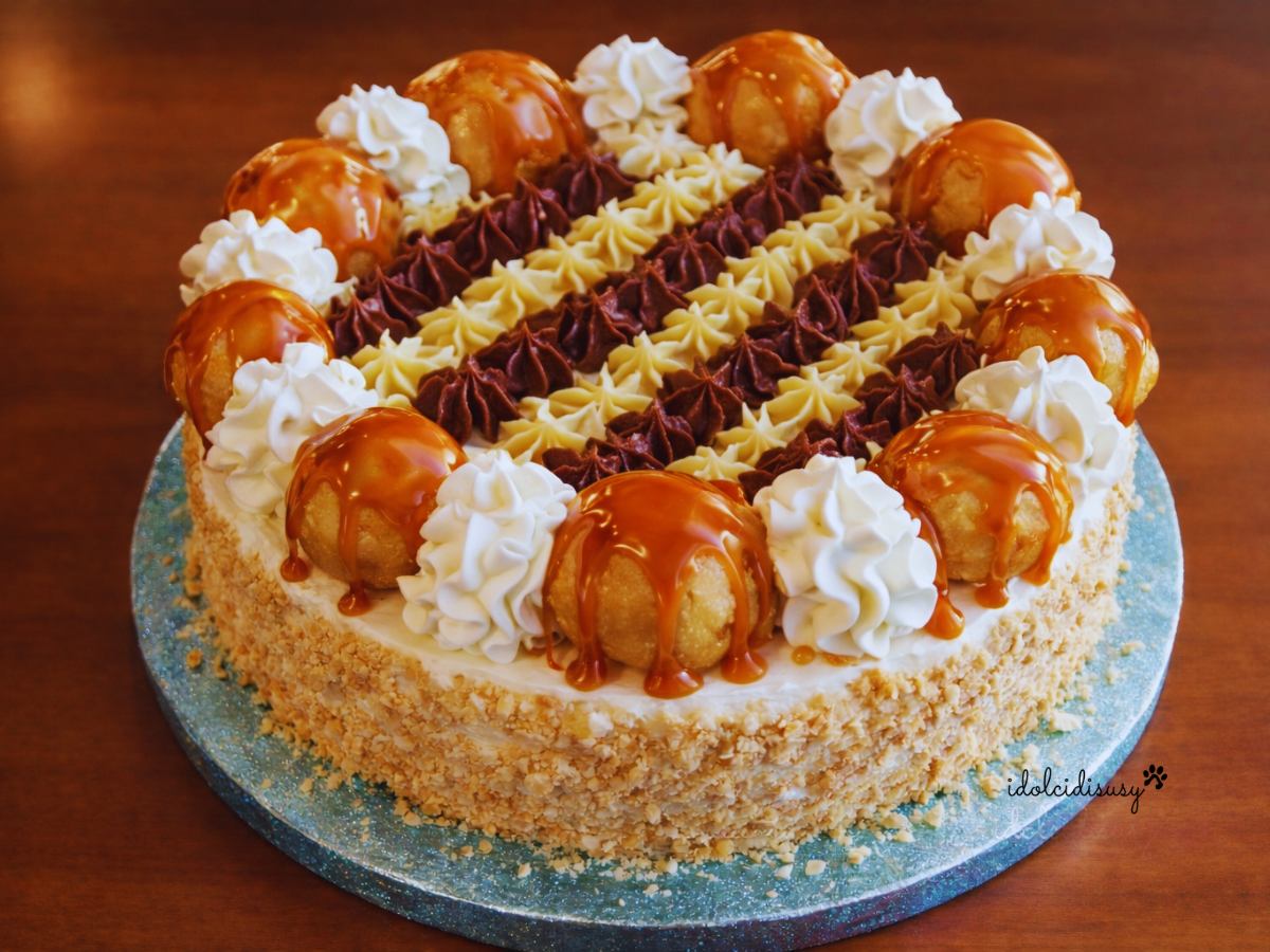 Torta Saint Honoré fatta in casa con bignè al caramello, ciuffi di panna montata e crema chiboust decorata a ciuffetti