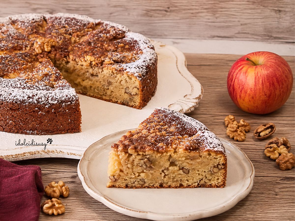 Torta di mele e noci con una fetta tagliata che mostra l’interno soffice con pezzetti di mela e noci