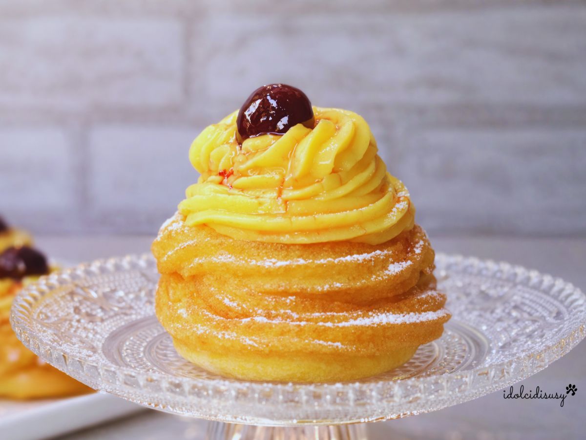 Zeppole di San Giuseppe fritte con crema pasticcera e amarena su alzatina in vetro