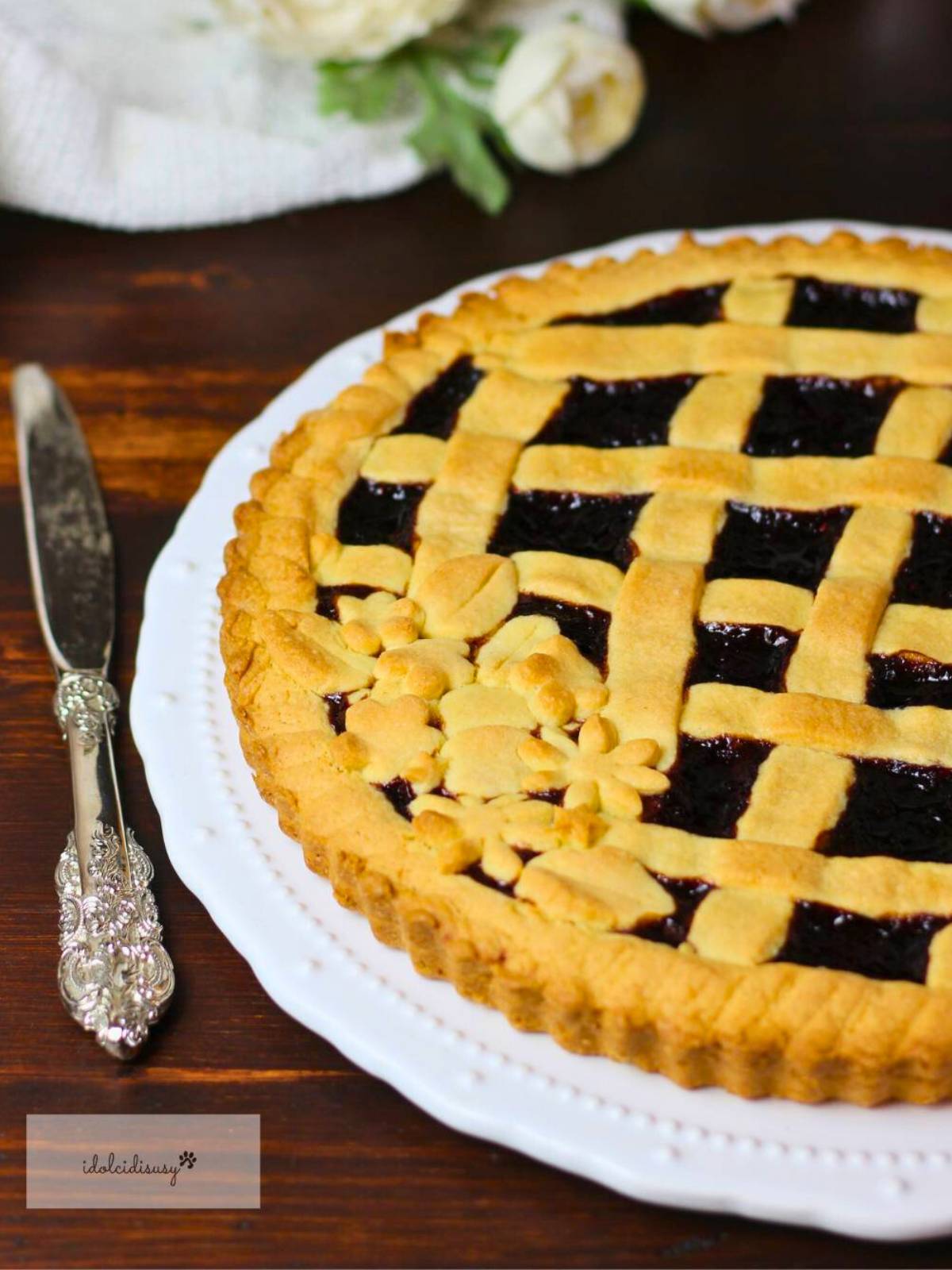 Dettaglio della crostata alla marmellata fatta in casa con intreccio di frolla e confettura scura.