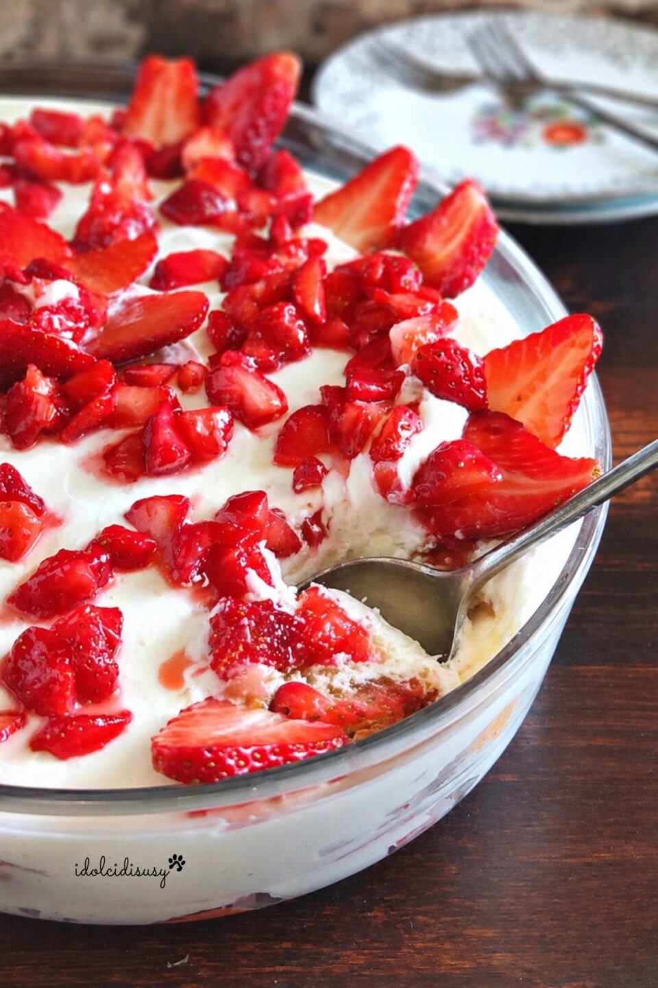 tiramisù alle fragole senza uova cremoso con cucchiaio affondato e fragole fresche
