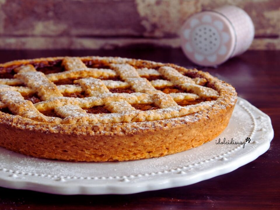 Crostata ricotta e marmellata con pasta frolla friabile, decorata con griglia di frolla e spolverata di zucchero a velo