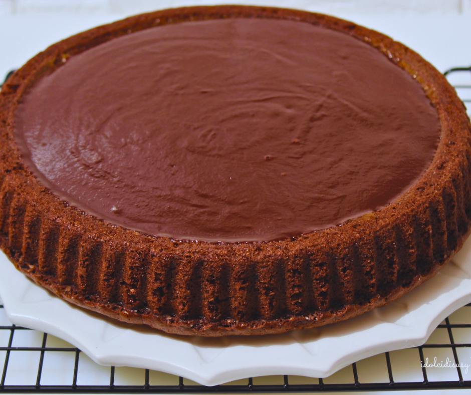 Base al cacao per crostata morbida Sacher appena ricoperta con glassa di cioccolato fondente lucida.