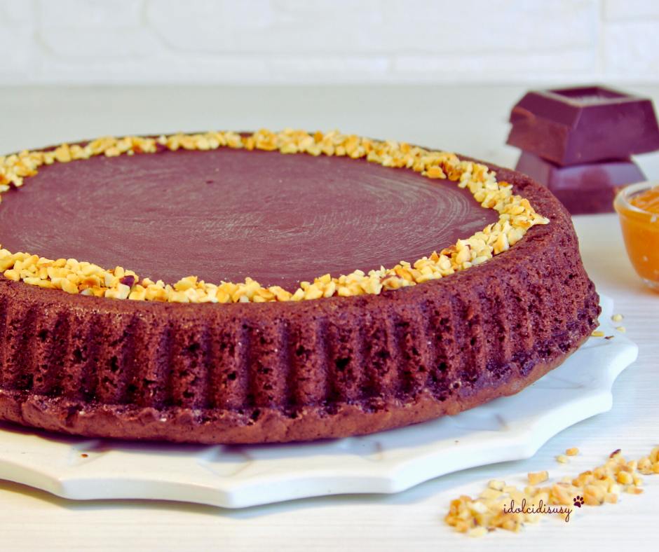 Crostata morbida Sacher decorata con granella di nocciole e glassa al cioccolato fondente, perfetta per colazione o dessert.