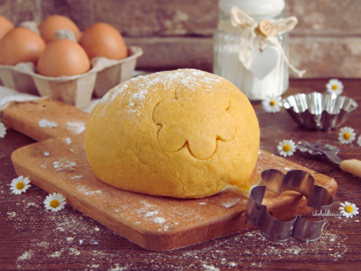 pasta frolla bimby fatta in casa con uova fresche e margherite sullo sfondo