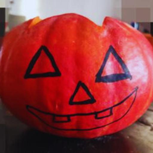 Zucca di Halloween con viso disegnato con il pennarello nero, pronta per essere intagliata
