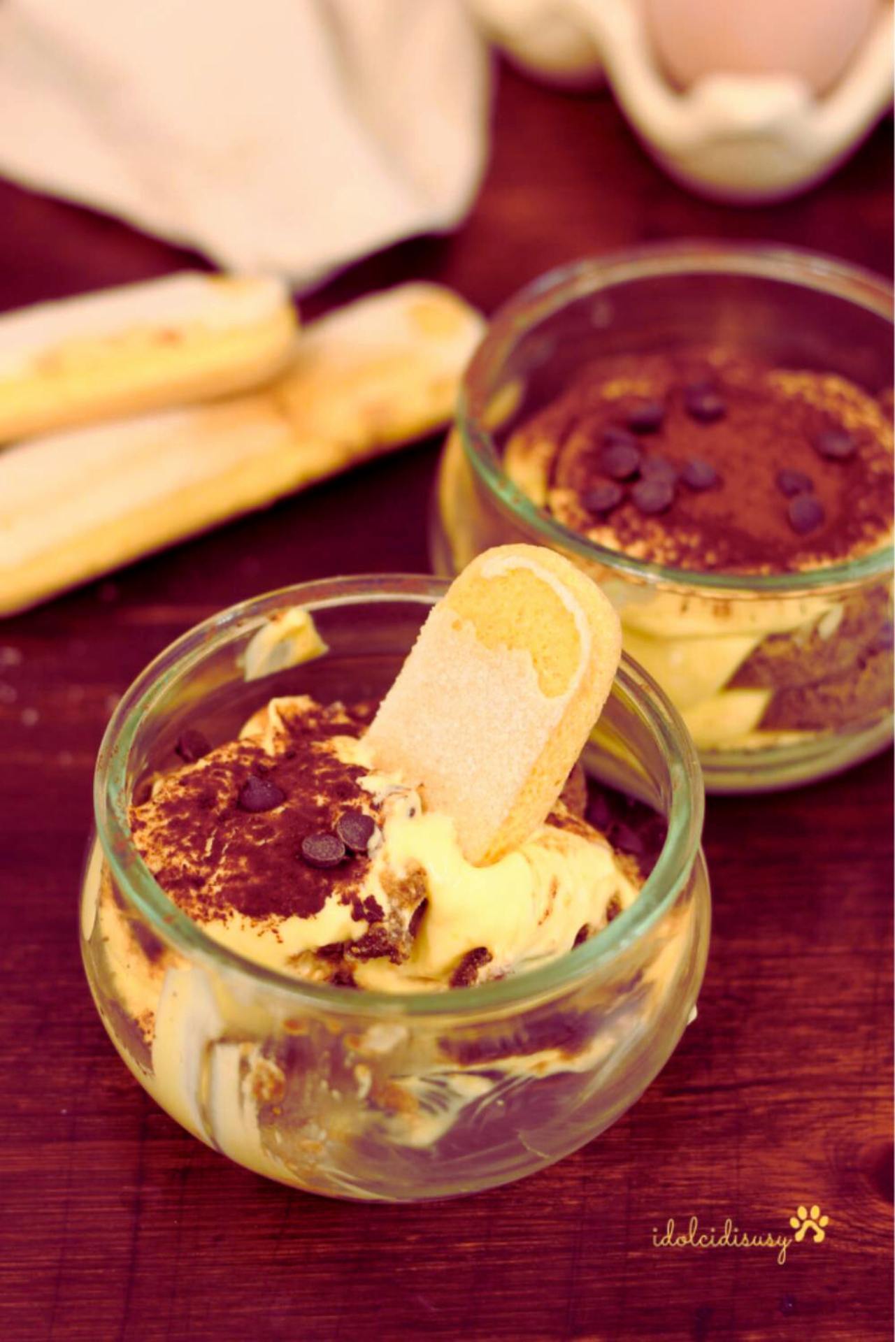 Tiramisù con uova pastorizzate servito in bicchieri monoporzione con savoiardi e cacao amaro