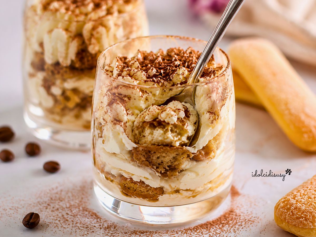 Cucchiaino affondato nel tiramisù al bicchiere cremoso senza uova