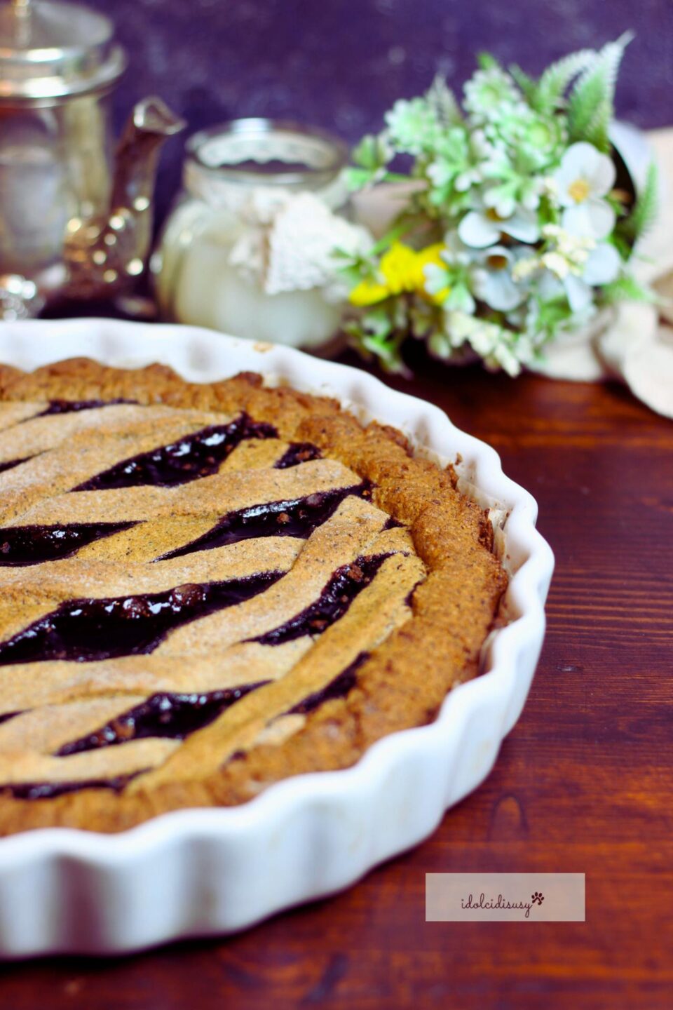 crostata di grano saraceno senza glutine servita su tavolo rustico con decorazione floreale