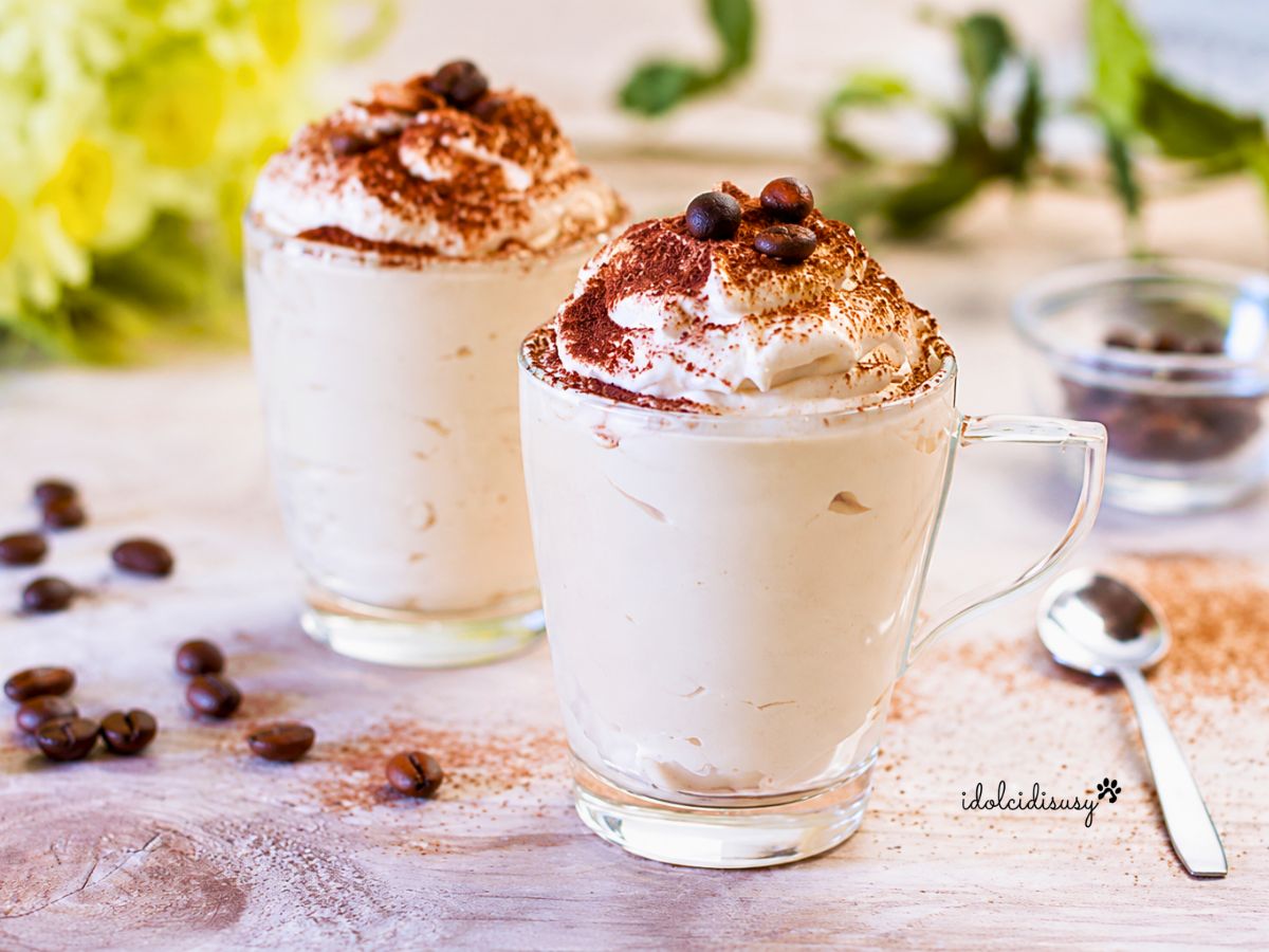 Bicchierini di crema fredda al caffè con mascarpone e panna decorati con cacao amaro e chicchi di caffè.
