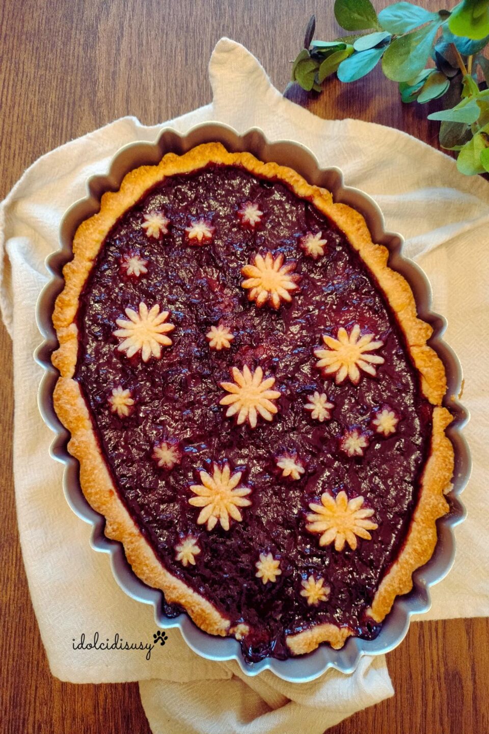 Crostata senza zucchero fit farcita con confettura di prugne e decorata con fiori di pasta frolla
