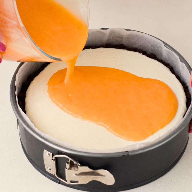 Verso la copertura al melone sulla crema allo yogurt della torta fredda.