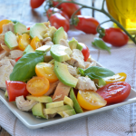 Insalata di pollo estiva con avocado e datterini gialli e rossi