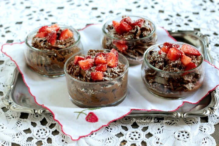 Mousse vegana al cioccolato e cocco servita in bicchierini con fragole fresche e cocco rapè