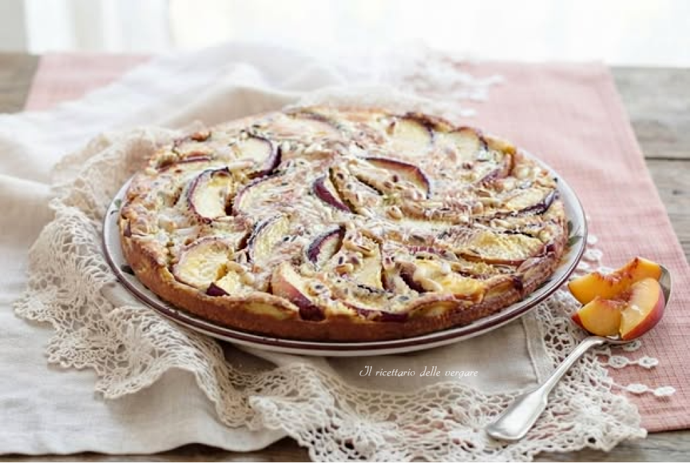 Clafoutis alle pesche e pinoli servito su un tavolo
