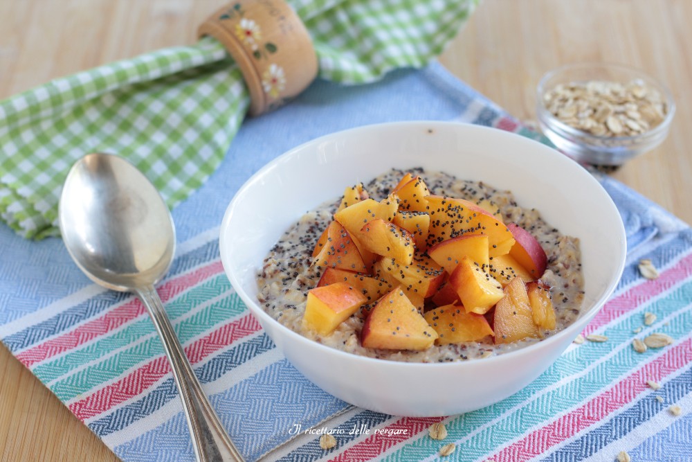 Porridge freddo estivo alle pesche senza cottura servito in una ciotola con cubetti di frutta fresca e cannella