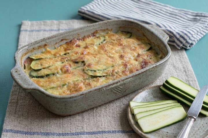 Parmigiana bianca di zucchine a crudo in pirofila con zucchine fresche affettate